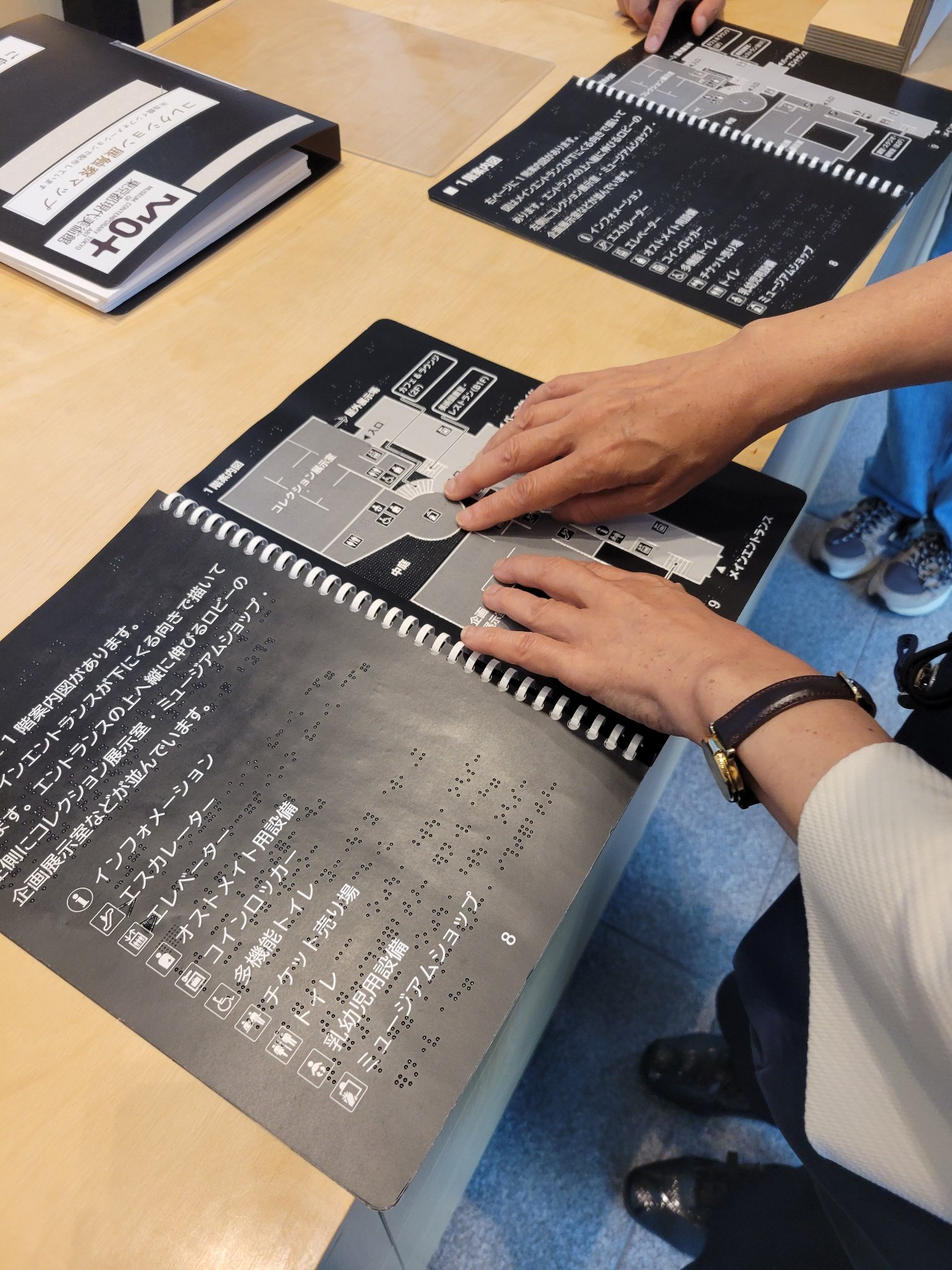 インフォメーションに設置している館内触知案内図を触る様子