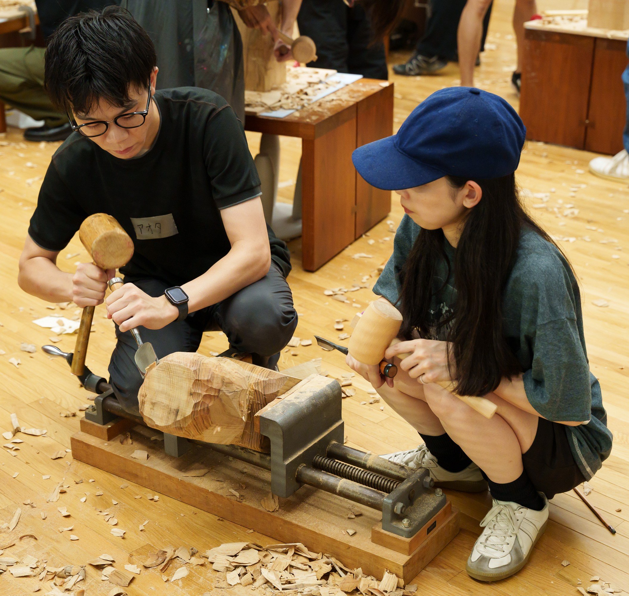 アシスタントの彫刻家が参加者の作品を彫っている姿