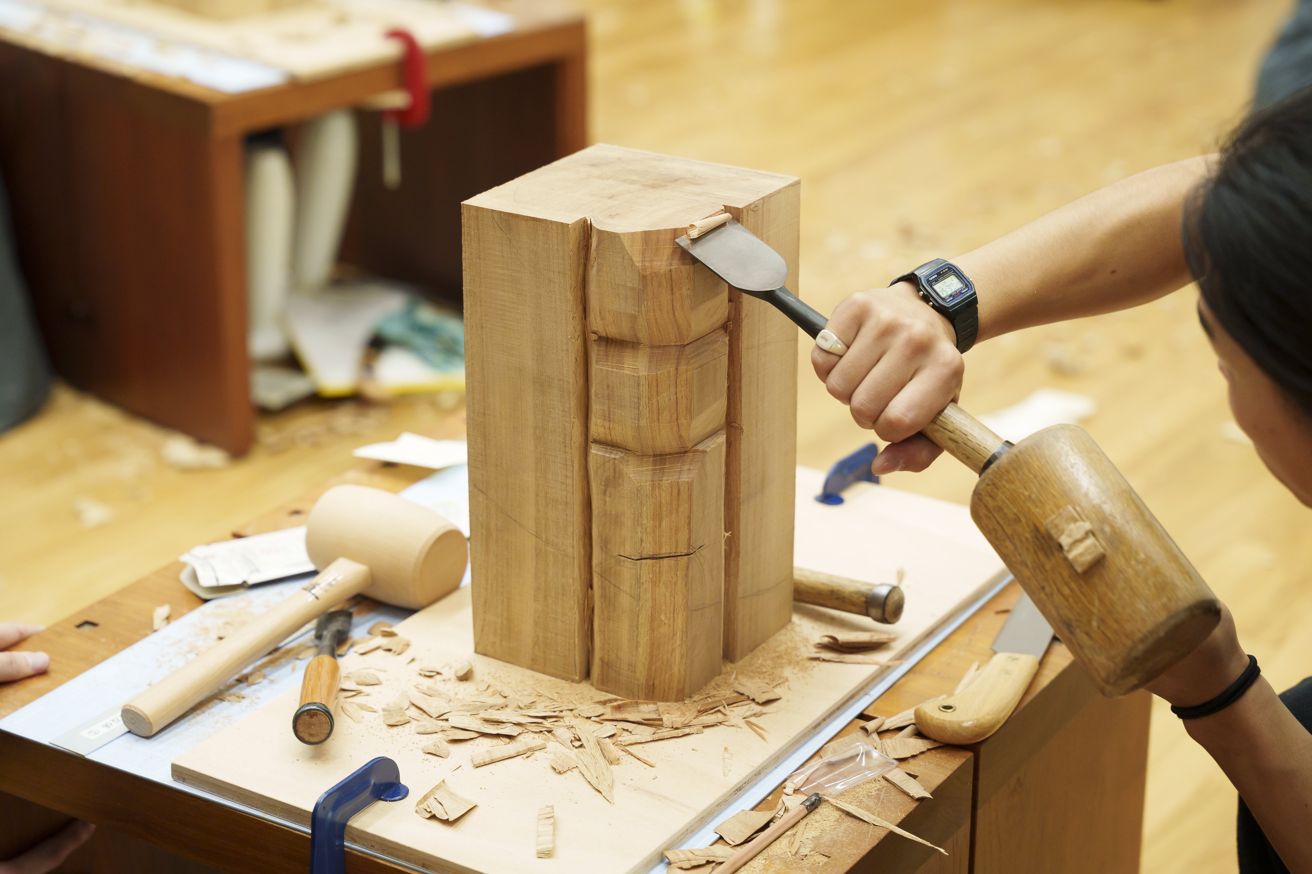 木のかたまりの一角を丸く彫り込んでいる様子